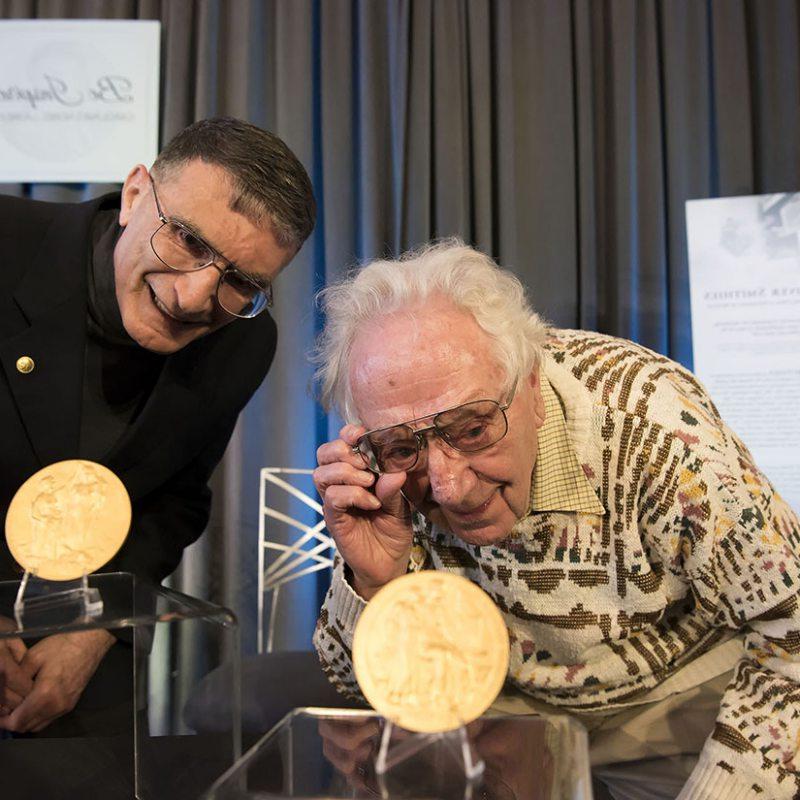 Oliver Smithes and Aziz Sancar look at their Nobel Prize Medals.